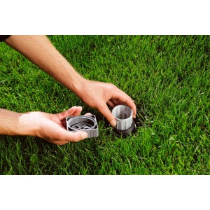 Gardena Zentralfilter für Sprinkler-Systeme im Rasen, mit Händen bei der Installation.