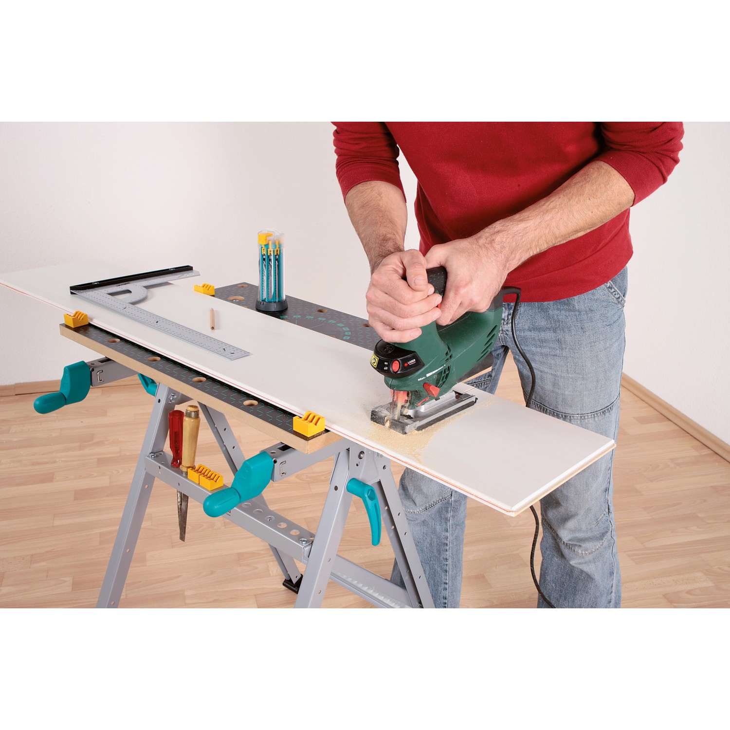 Wolfcraft Master 200 Werkbank: Mann sägt Holzplatte mit Stichsäge auf Arbeitstisch.