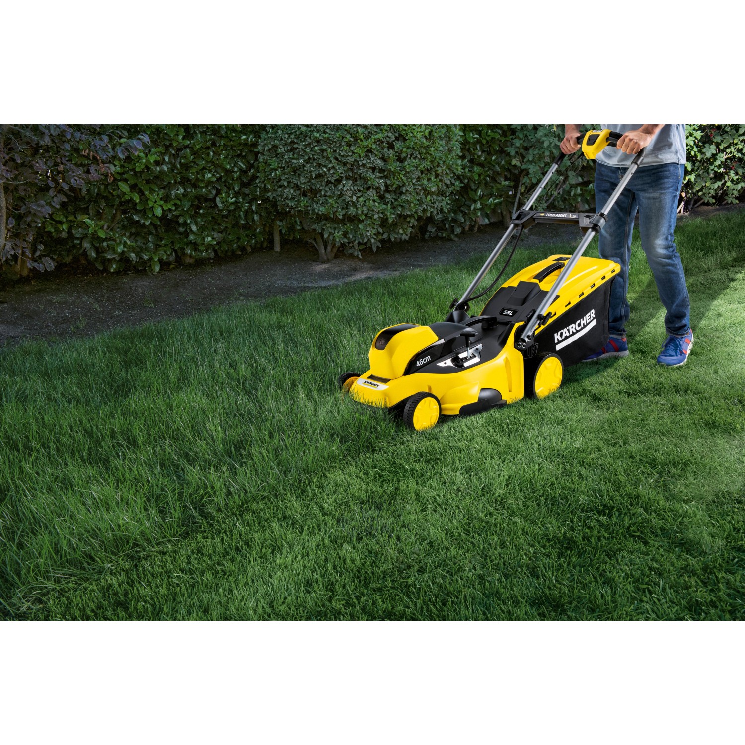 Gelber Kärcher Akku-Rasenmäher LMO 36-46 mit Akku im Einsatz auf Rasenfläche.