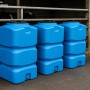 Drei blaue, quadratische KMND 500L Wassertanks aus PE mit schwarzem Deckel, für Trinkwasser oder Regenwasser. Regentonnen.