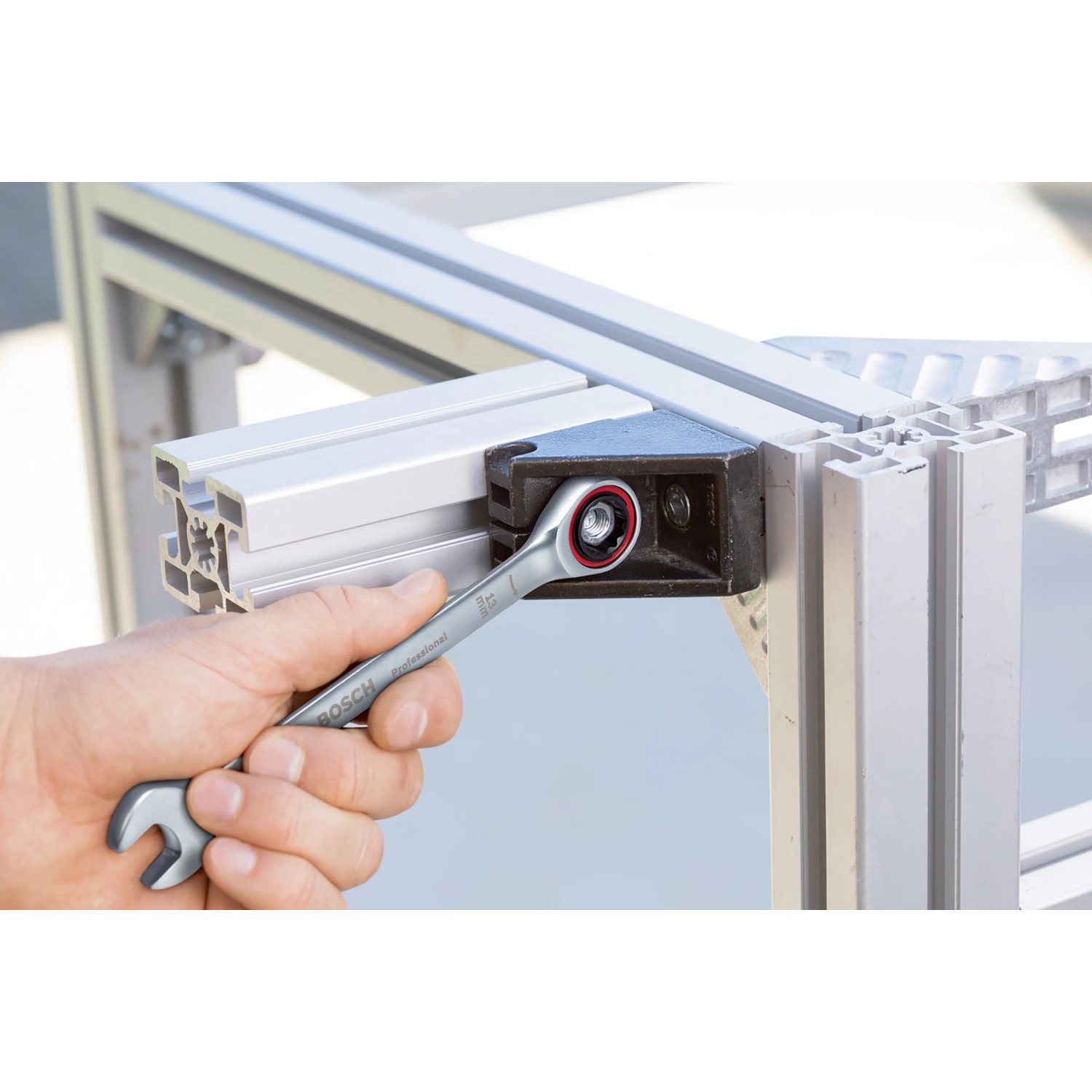 Bosch Professional Ringratschenschlüssel beim Schrauben an einem Aluminiumrahmen.
