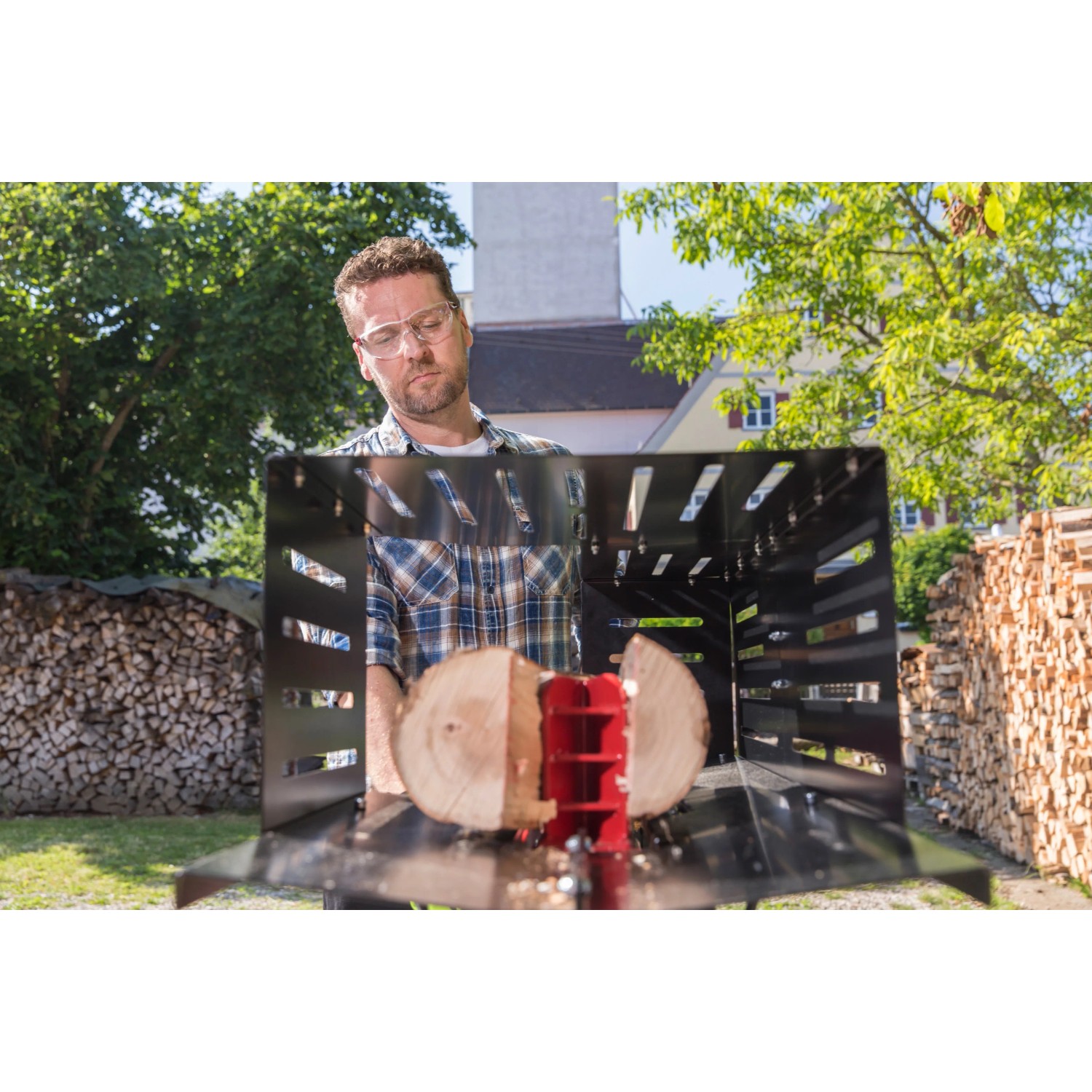 Mann spaltet Holz mit dem Al-Ko Elektroholzspalter LSH 520/5 im Garten.