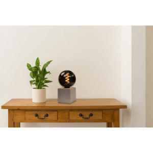 Dimmbares E27 LED Filament Leuchtmittel (4W, 1800K) mit Rauchglas auf einem Tisch.