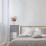 Weiße Relaxdays Blumenvase mit Gesicht auf Nachttisch mit Blumenstrauß im Schlafzimmer.