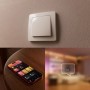 Philips Hue Wandschaltermodul: Weißer Schalter an Wand, Smartphone mit Hue App für smarte Lichtsteuerung.