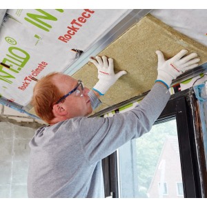 Mann montiert Rockwool Formrock Untersparrendämmung (60mm) zwischen Sparren. Mineralfaser Dämmstoff.