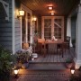 Beleuchtete Terrasse mit Philips Hue Econic Sockelleuchten und Wandleuchten in warmem Licht.