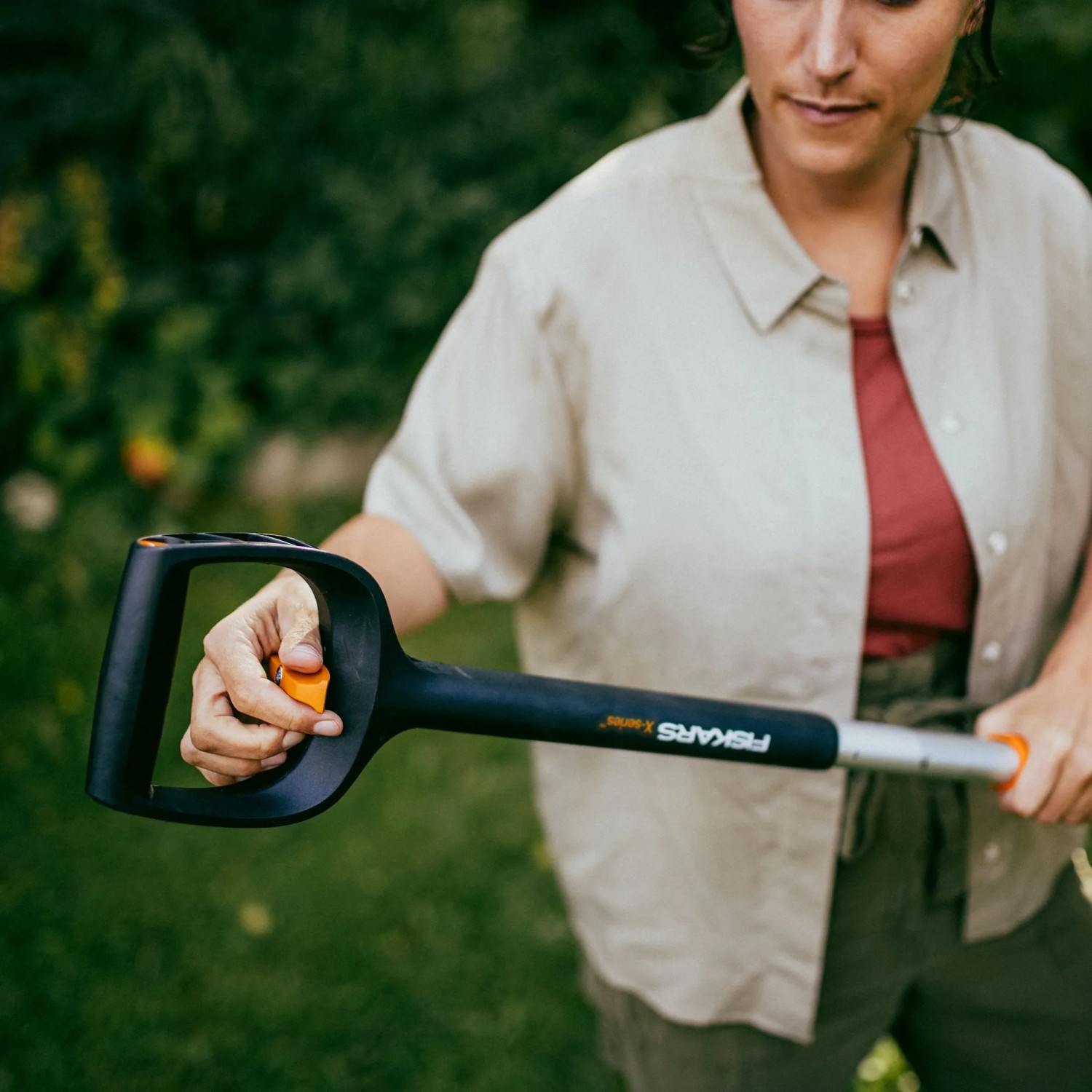 Frau bedient Fiskars Unkrautstecher X-Series mit D-Griff zur Bodenbearbeitung im Garten.
