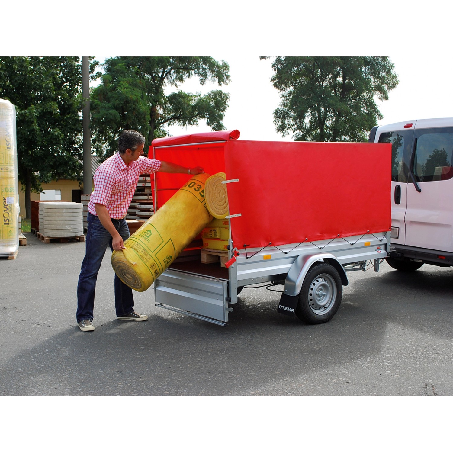 Stema Anhänger Variolux 850 mit roter Plane und Stützrad beim Beladen.