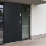 Moderne anthrazitgraue Stahleingangstür Agueda mit Glasseitenteil und silbernem Griff in weißer Fassade.