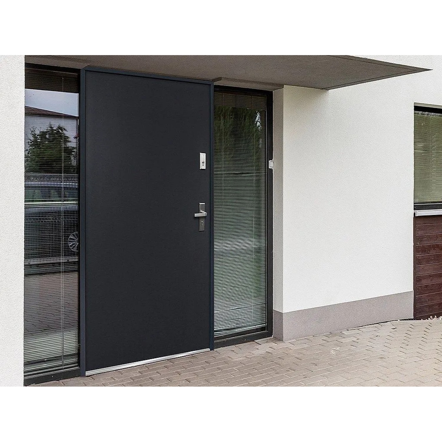 Moderne anthrazitgraue Stahleingangstür Agueda mit Glasseitenteil und silbernem Griff in weißer Fassade.
