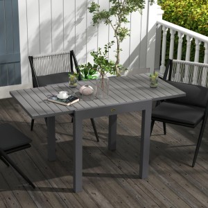 Grauer ausziehbarer Gartentisch aus Aluminium mit Lattenrost-Tischplatte auf Holzterrasse.