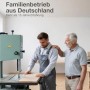 K-Möbel Möbelfüße: Zwei Handwerker in Werkstatt, einer an Säge, der andere legt Hand auf Schulter.