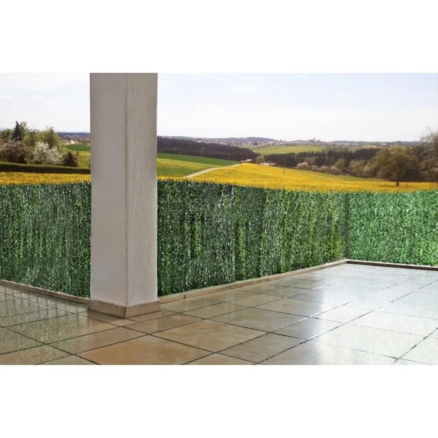 Grüner Balkonsichtschutz in Tannenoptik auf Terrasse mit Landschaft im Hintergrund. Ideal für Markisen & Sonnenschutz.