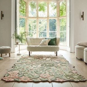 Mehrfarbiger Flair Rugs Bryony Wollteppich mit geformtem floralem Design auf hellem Holzboden im Wohnzimmer.