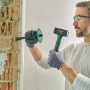 Mann beim Stemmen einer Wand mit Bosch Fäustel (1 kg) und Meißel. Hammer der Kategorie Hämmer.