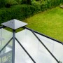 Detailaufnahme des Juliana Gewächshauses Oase 13 in Anthrazit, Fokus auf Dachkonstruktion und Umgebung.