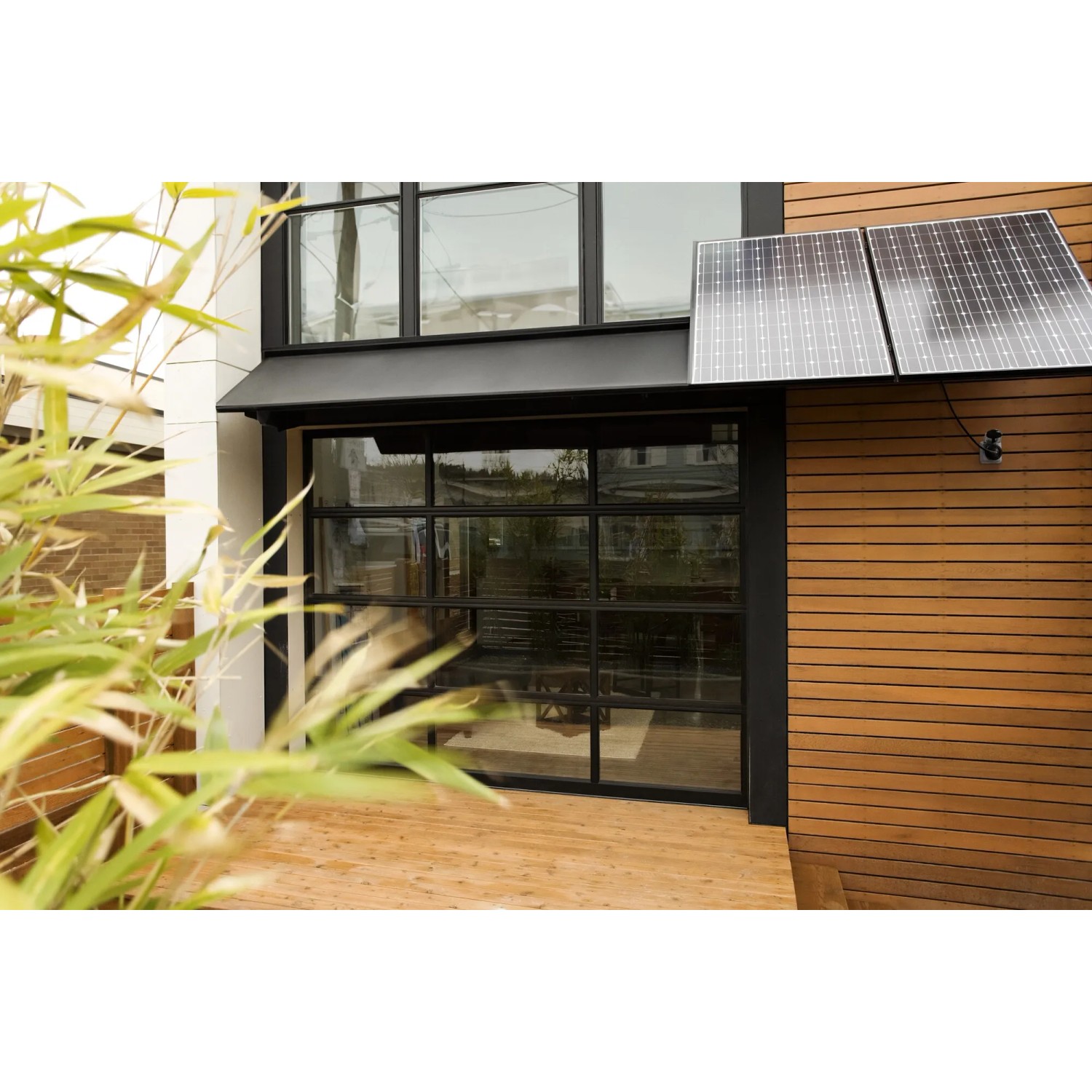 Osram Smart+ WiFi Außensteckdose im Einsatz an Hauswand mit Solarpanelen.