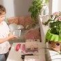 Lechuza Ojo Pflanzgefäß in Apfelgrün mit Playmobil-Optik und Kind im Hintergrund.