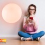 Frau steuert weiße Globo LED-Deckenleuchte Sajama I per App.