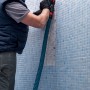 Handwerker beim Fliesenschleifen mit Bosch Expert Schleifplatte Multi Material MAVZ116 RT2.