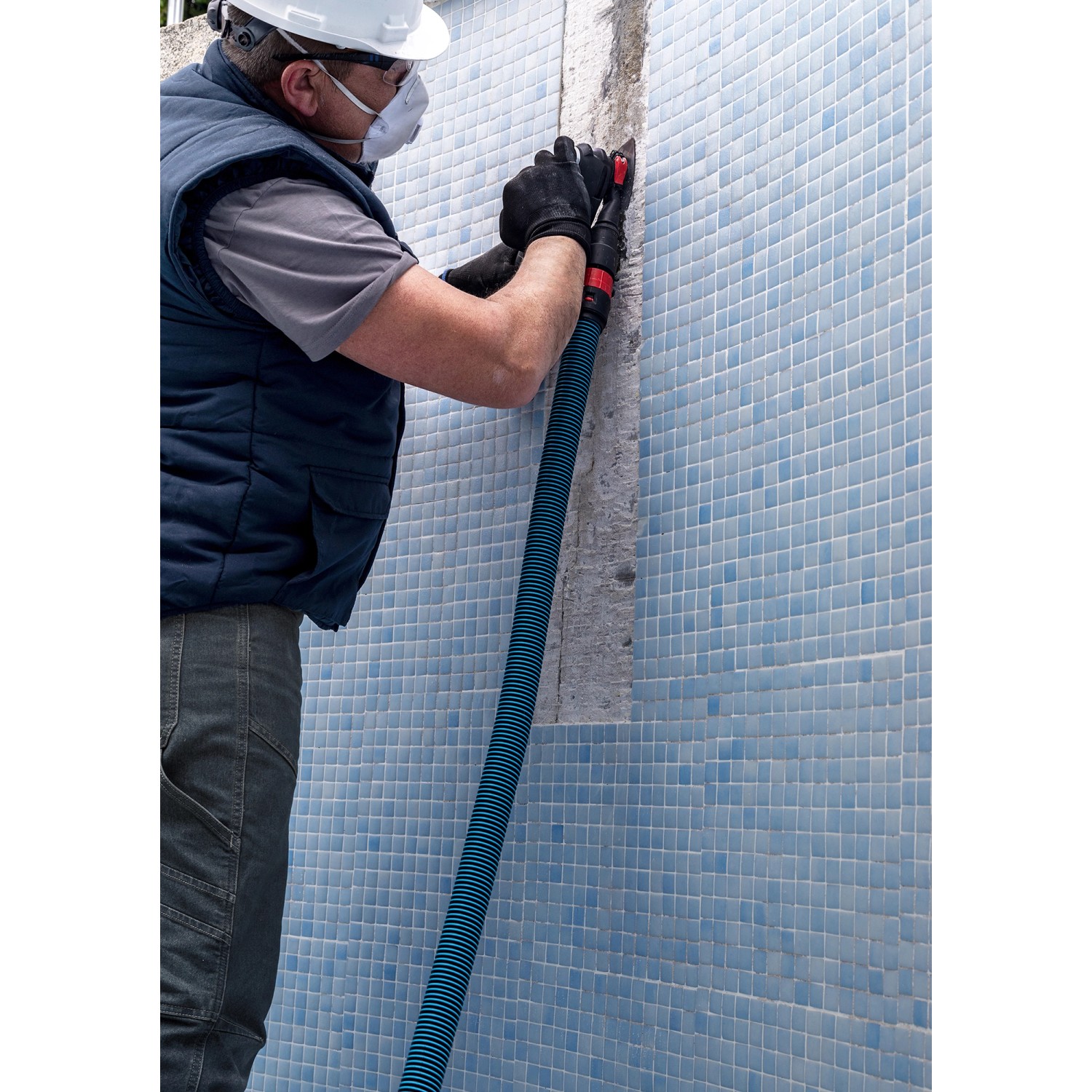 Handwerker beim Fliesenschleifen mit Bosch Expert Schleifplatte Multi Material MAVZ116 RT2.