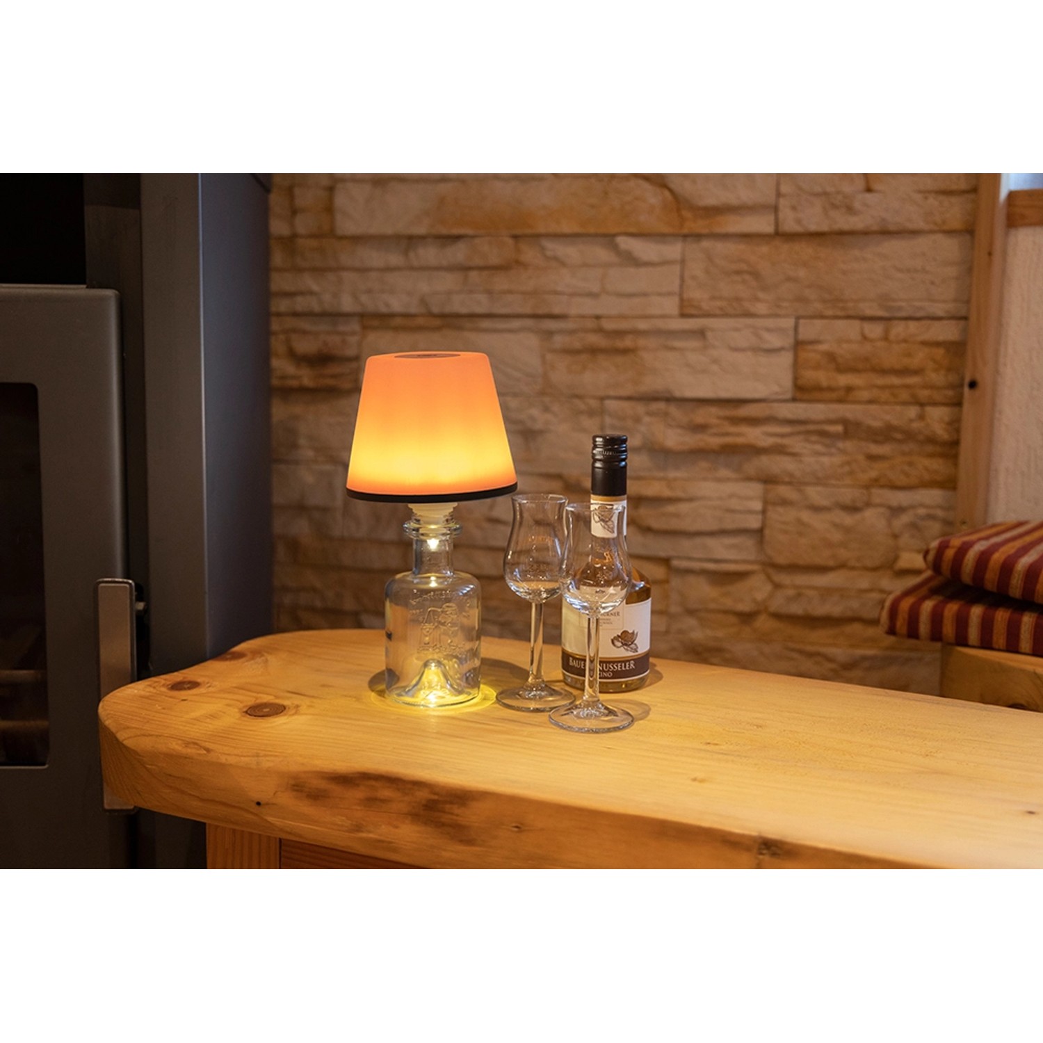 REV Ritter LED Flaschenleuchte Lamprusco mit Akku, RGBW, auf Holztisch.