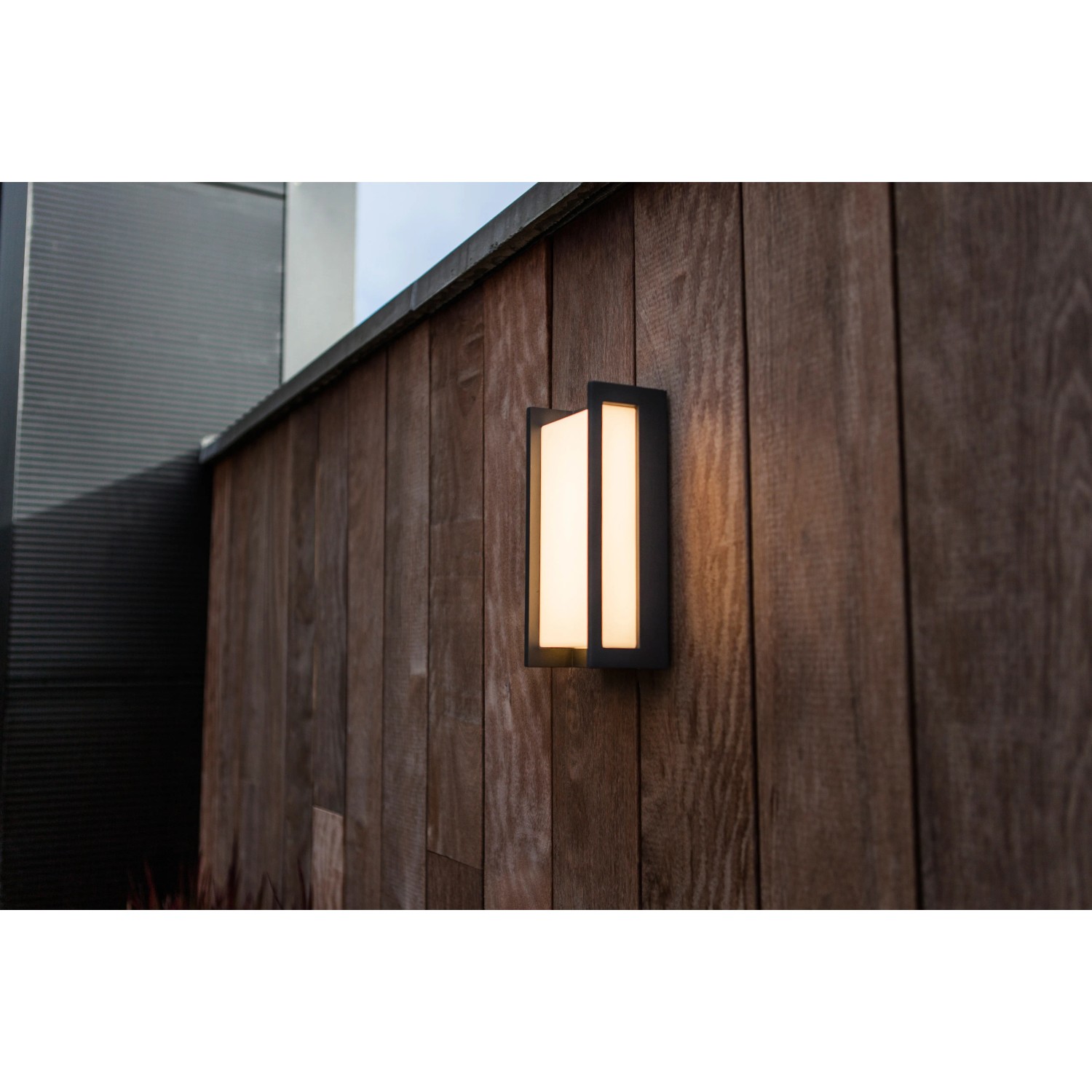 Moderne Lutec LED-Außenwandleuchte Qubo an einer Holzwand. Quadratische Form, warmweißes Licht.