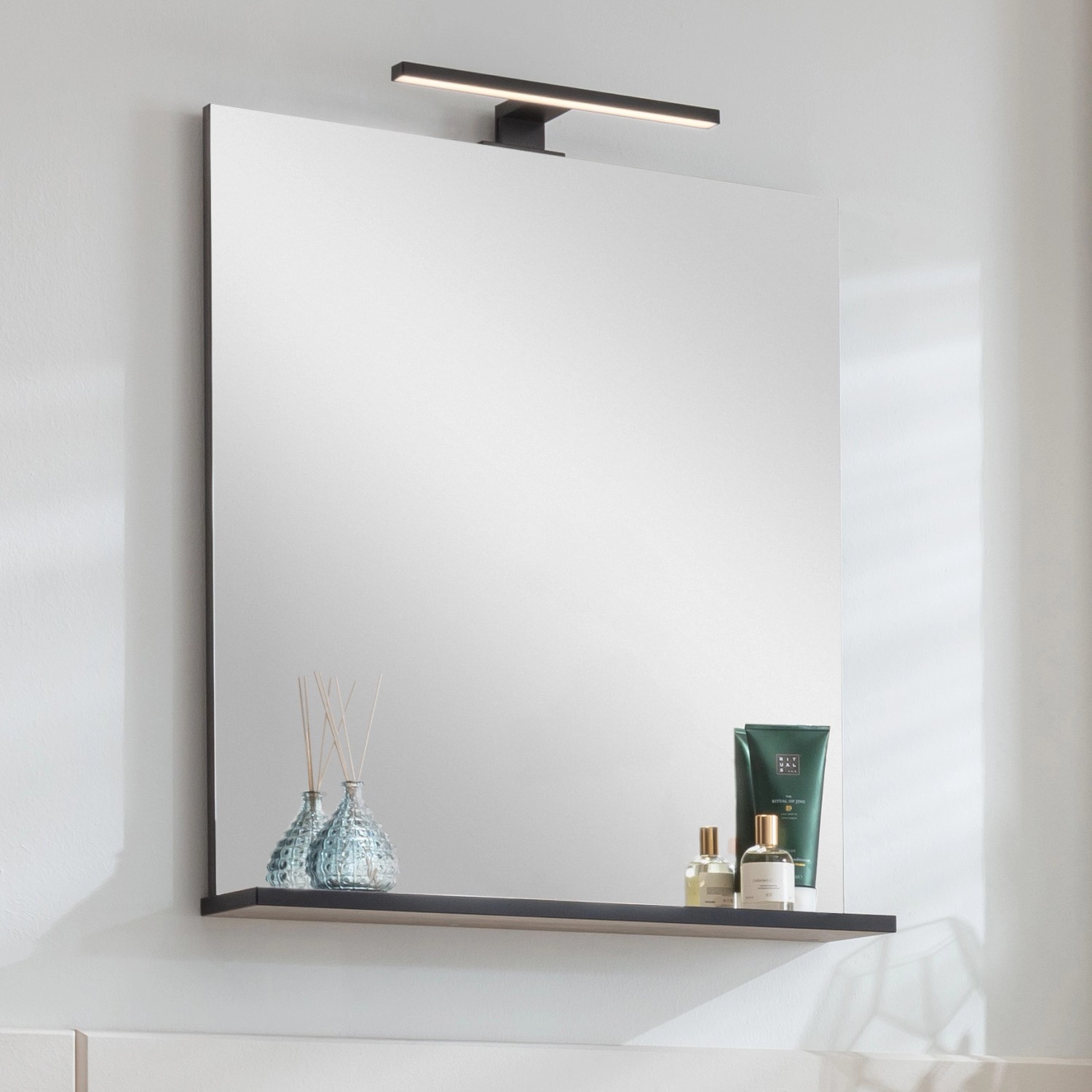 Fackelmann LED-Aufsatzleuchte, 30cm, Schwarz Matt, montiert über einem Spiegel im Badezimmer.