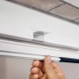 Detailaufnahme: Weiße Tesa Fliegengittertür mit Alu-Rahmen und Hand, die den Rahmen berührt.