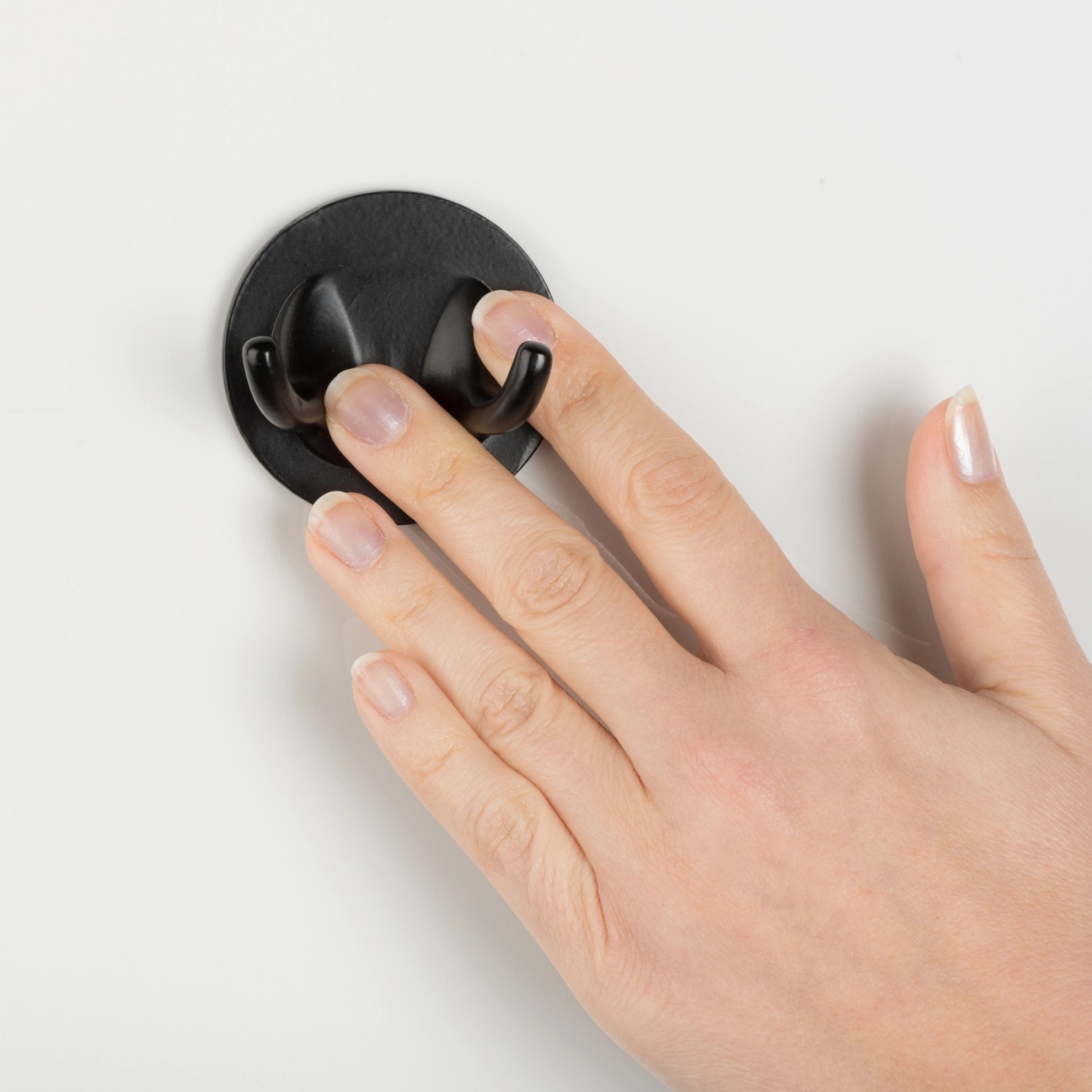 Montage des schwarzen WENKO Bambusa Turbo-Loc® Badhelfers an einer weißen Wand.