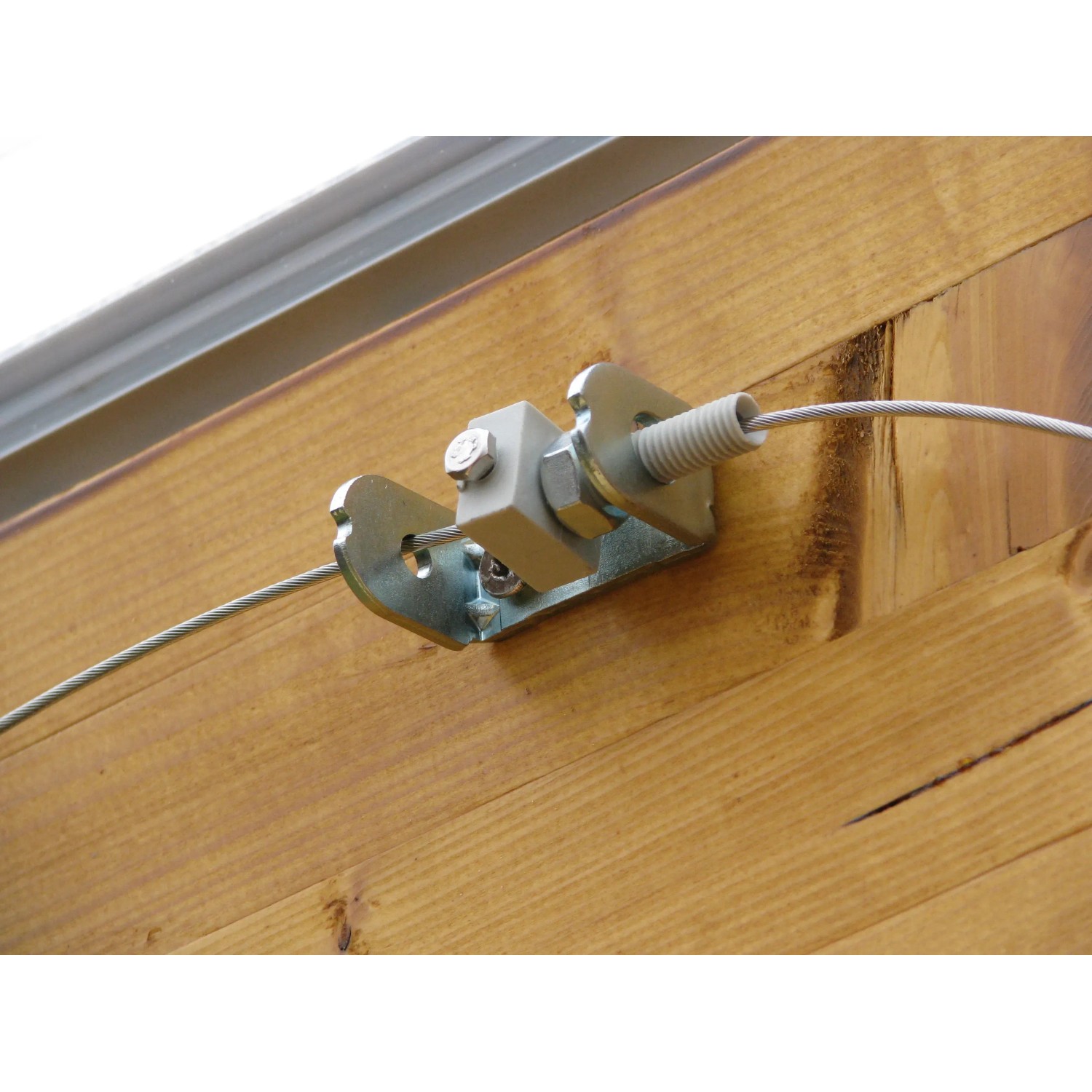 Detailaufnahme: Floracord Seilspanntechnik Bausatz mit Edelstahlseil und Spanner an Holzwand.