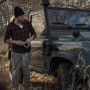 Mann mit Tesa Reparaturband Ultra Power Extreme vor Geländewagen in der Natur.