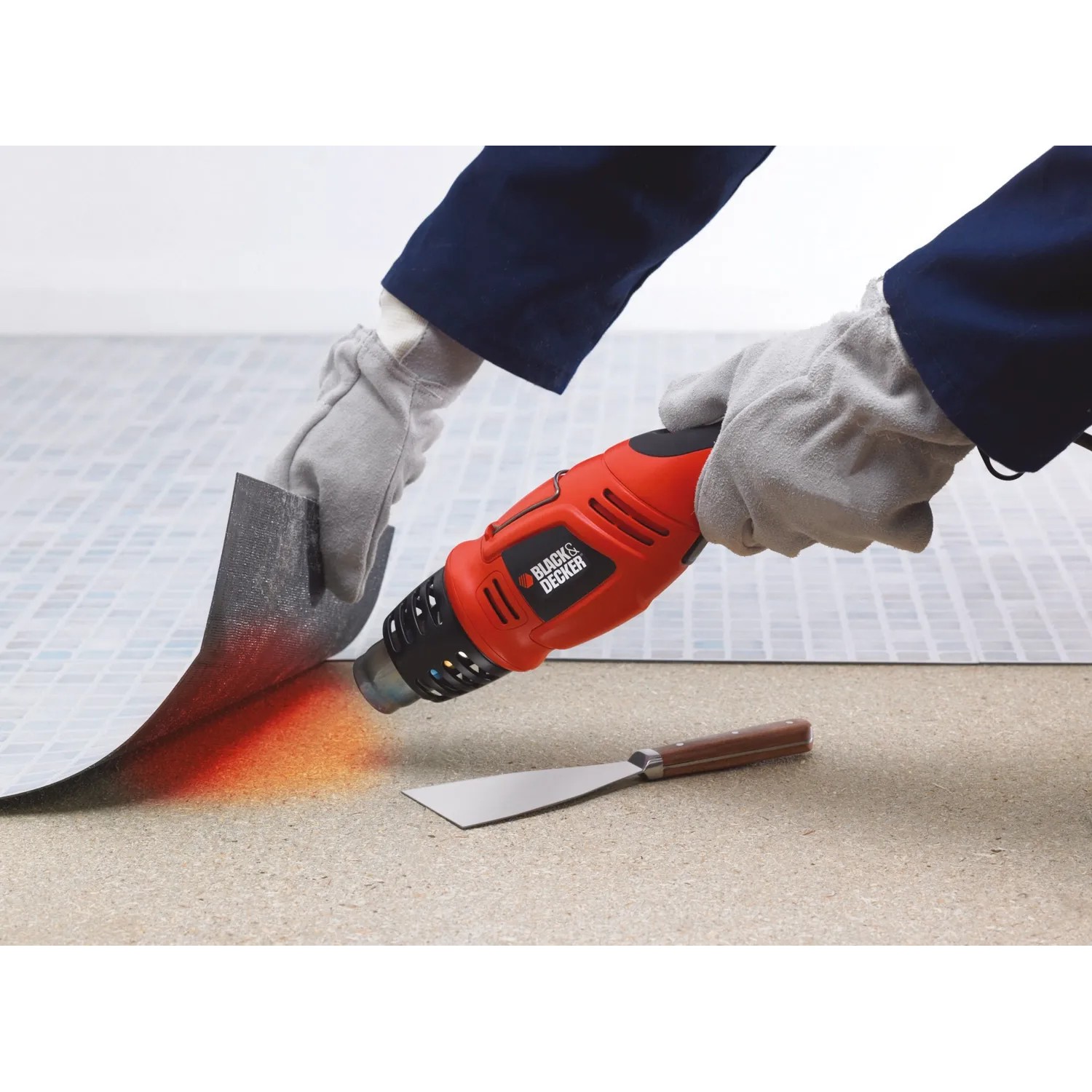 Black+Decker Heißluftgerät KX1693 in Nutzung mit Farbschaber zum Ablösen von Material.