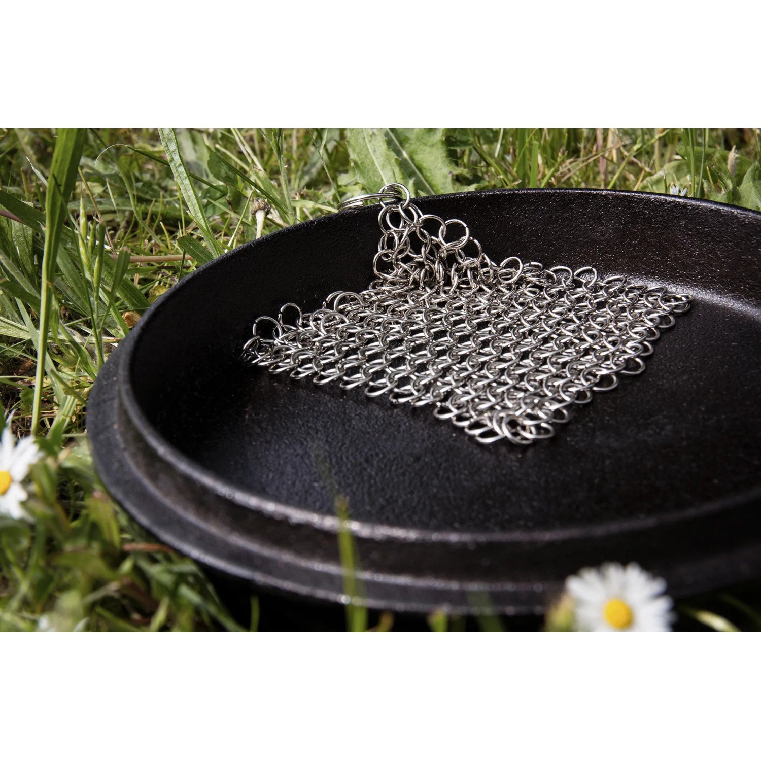 Petromax Dutch Oven Set: Gusseisen-Topf mit Ringreiniger auf Wiese.