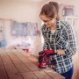 Frau schleift Holz mit Einhell Exzenterschleifer. Q-Stick Schleifpapier-Set Ø 125 mm