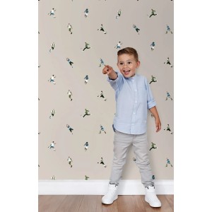 ESTAhome Vliestapete mit beigen Fußballspielern. Ein Kind zeigt auf das fröhliche Muster an der Wand im Kinderzimmer.