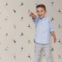 ESTAhome Vliestapete mit beigen Fußballspielern. Ein Kind zeigt auf das fröhliche Muster an der Wand im Kinderzimmer.