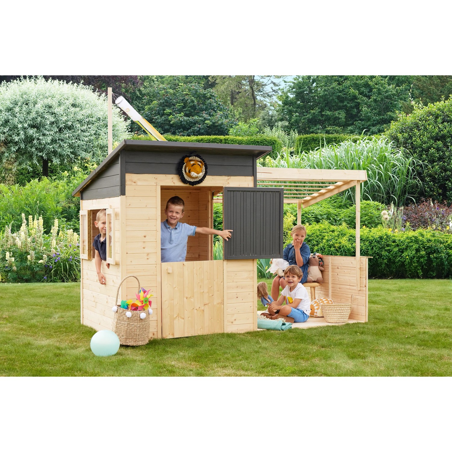 Soulet Kinderspielhaus Santa Barbara mit Anbau und spielenden Kindern im Garten.