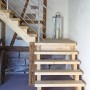 Dieda Geländerset aus Aluminium mit waagerechten Rundstäben an Holztreppe im Innenraum.