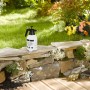 Schwarzer Relaxdays Drucksprüher aus Kunststoff mit Messingdüse vor Gartenkulisse.