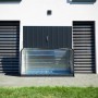 Geöffnete Trimetals Aufbewahrungsbox Storeguard, anthrazit, vor einer weißen Hauswand.