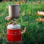 Evocamp Gaskartusche mit Campingkocher und Topf auf Rasen. Propan-Butan-Gemisch für Campingkocher.