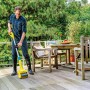 Mann reinigt Holzterrasse mit Gloria Holzbürste Universal. Gartenhandgerät im Einsatz.