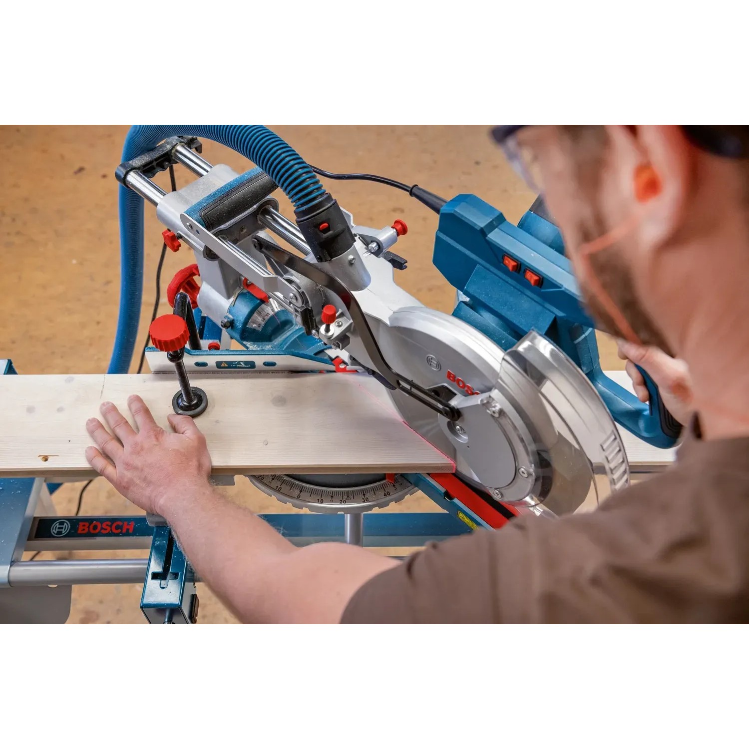 Bosch Professional GCM 305-254 Kapp- und Gehrungssäge beim Zuschnitt eines Holzbretts.