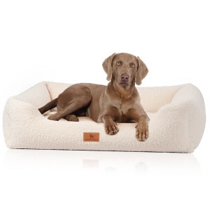 Beiges Knuffelwuff Hundebett Wollekopp XXL mit Hund, orthopädisches Kunstfell für großen Liegekomfort.