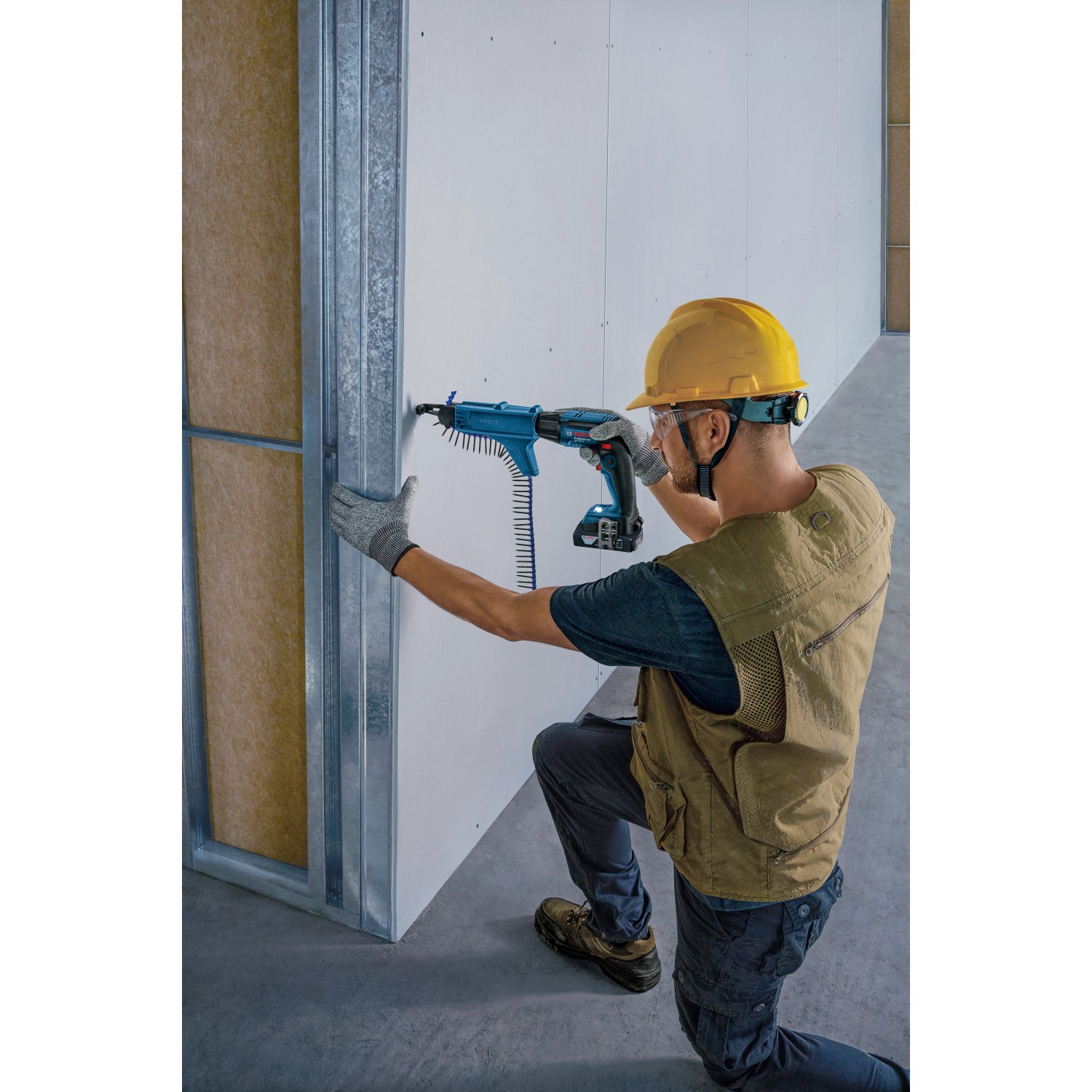 Handwerker mit Bosch Professional Akku-Trockenbauschrauber GTB 18V-45 beim Schrauben an einer Wand.