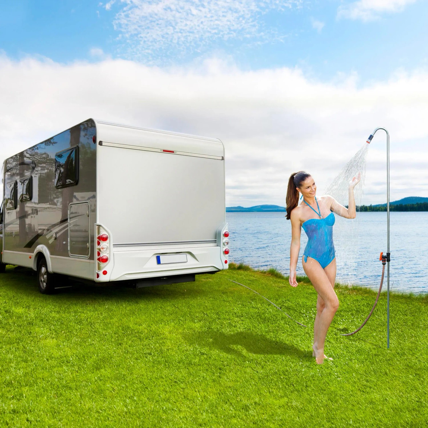 Frau duscht mit Gardena Akku-Klarwasser-Tauchpumpe neben Wohnmobil. Elektro-Pumpe für Camping.