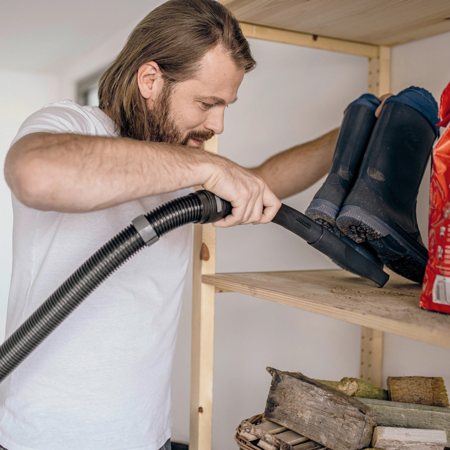 Mann saugt Regal mit Kärcher Nass-/Trockensauger WD 5 S V-25/5/22.