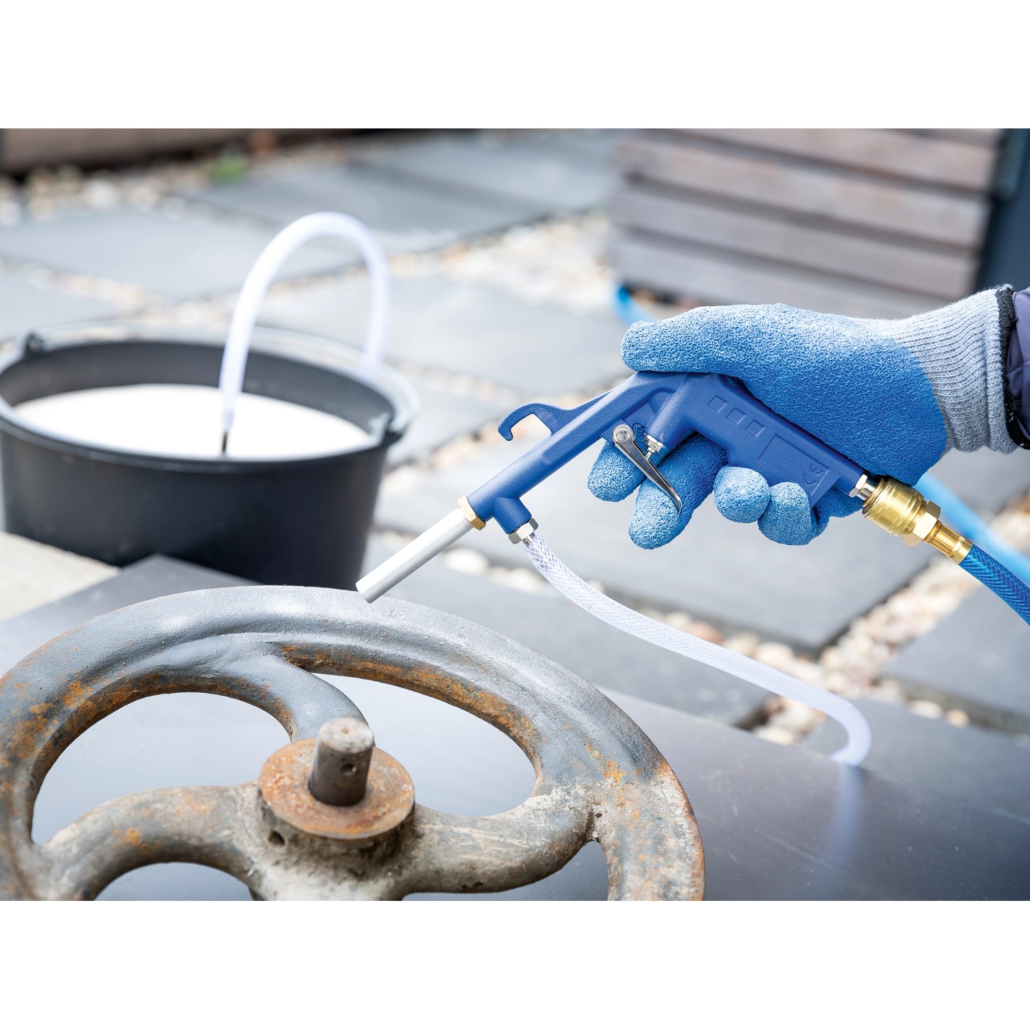 LUX Sandstrahlpistole D-SSP-180 im Einsatz zum Entrosten eines Metallrads.